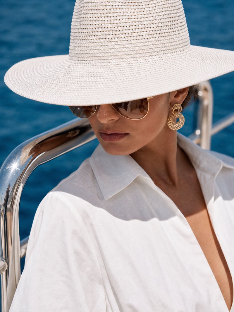Close crop on the hat brim, sunglasses and gold earring